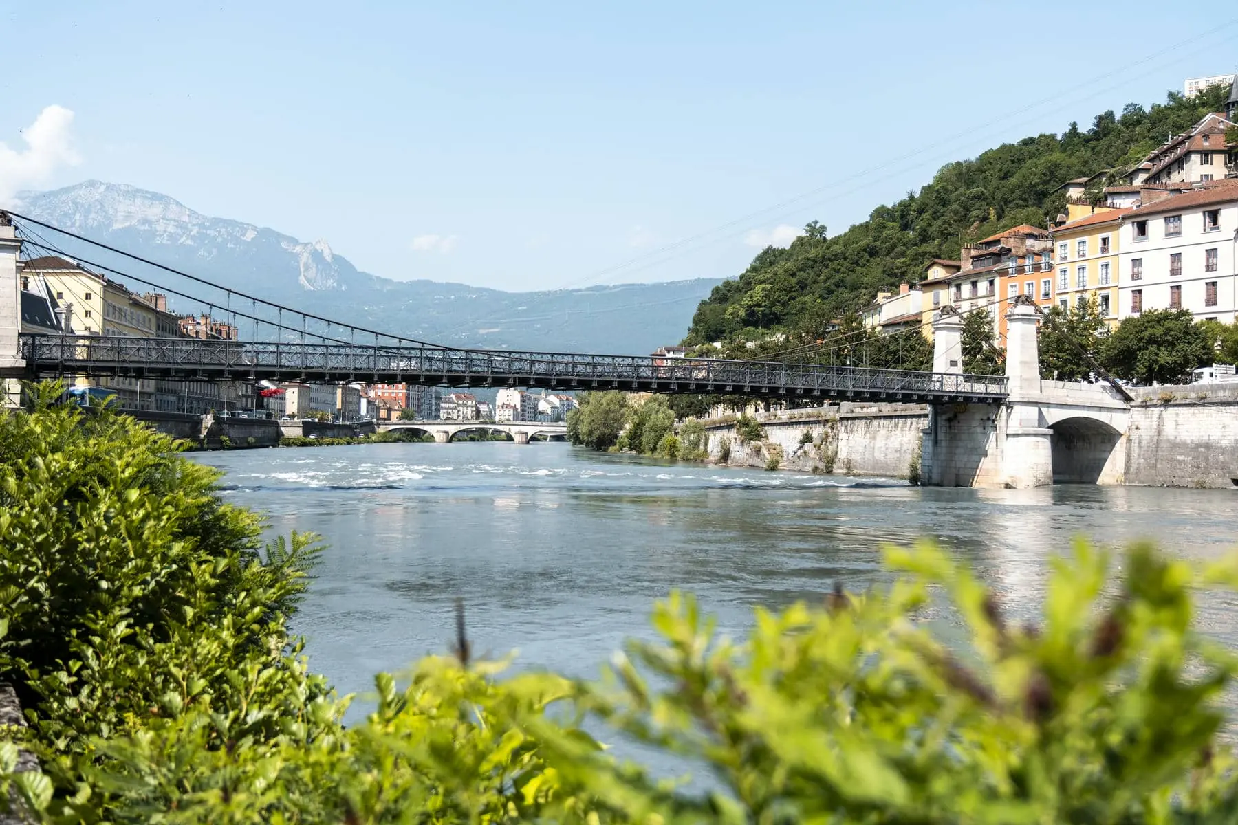 a bridge over a river with mountains in the background