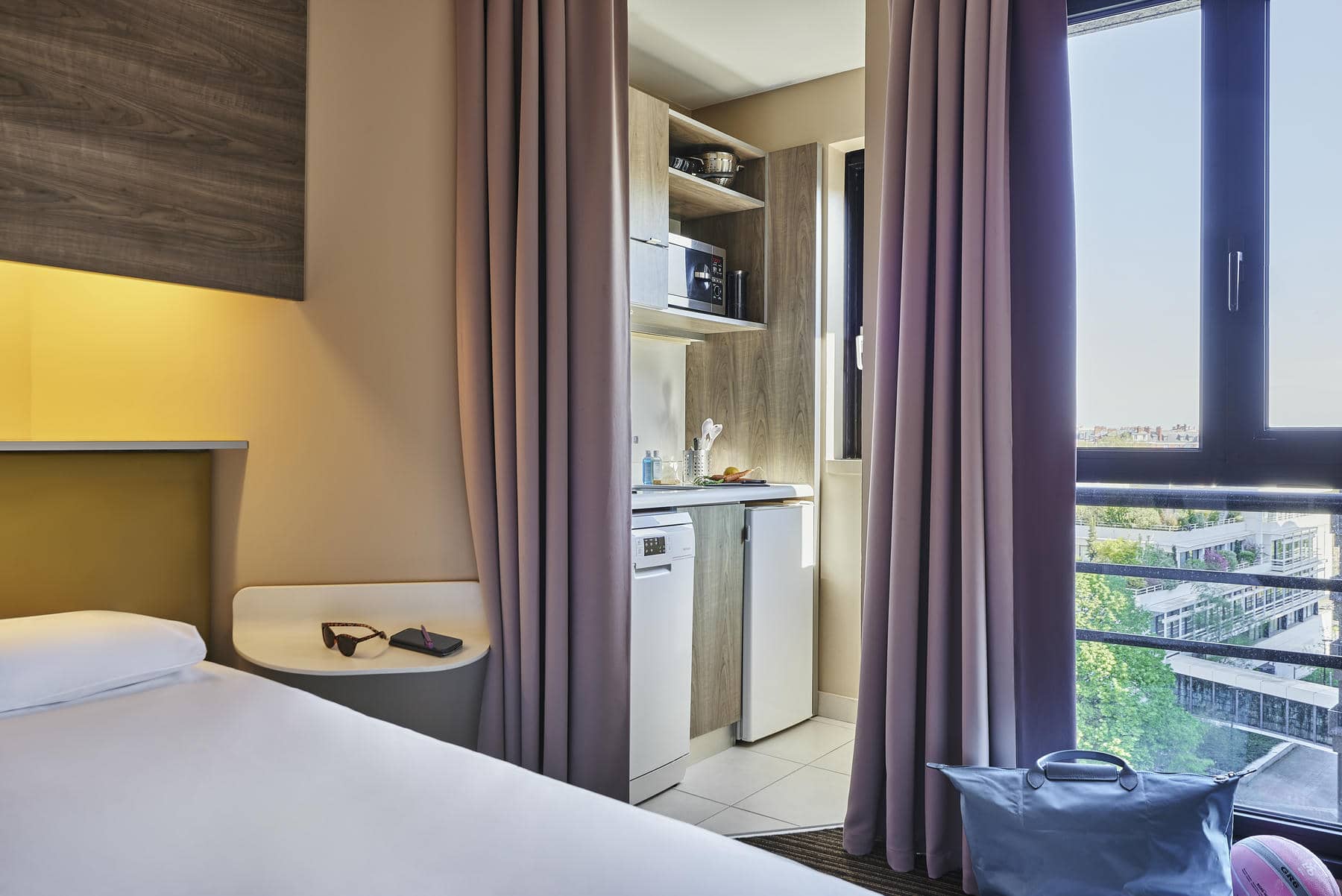 a hotel room with a small kitchen in the corner