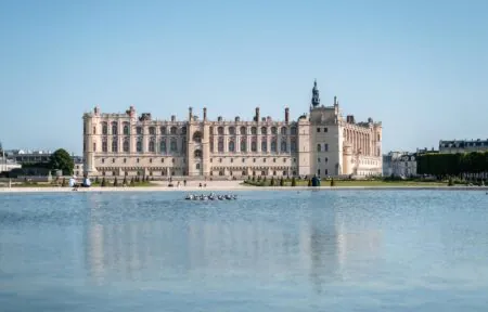 un grand bâtiment se reflète dans une étendue d'eau