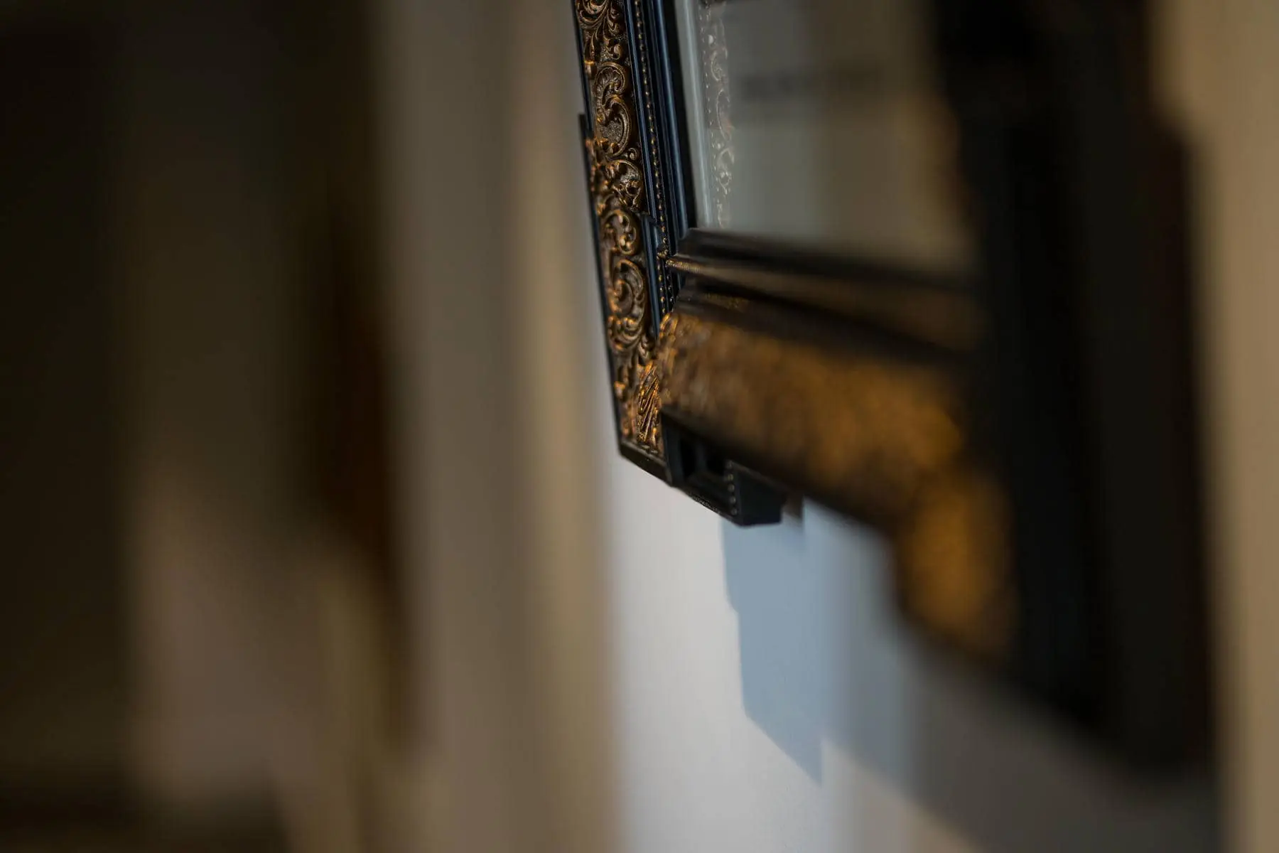 un miroir noir et or est accroché au mur