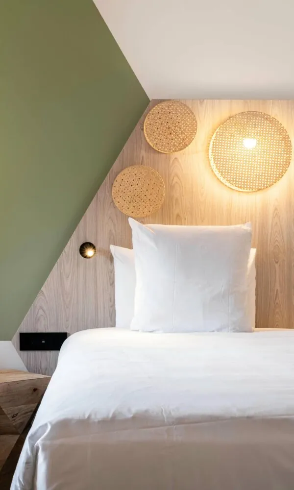 un lit dans une chambre d'hôtel avec une tête de lit en bois
