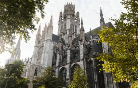 a large white building with a very tall tower surrounded by trees