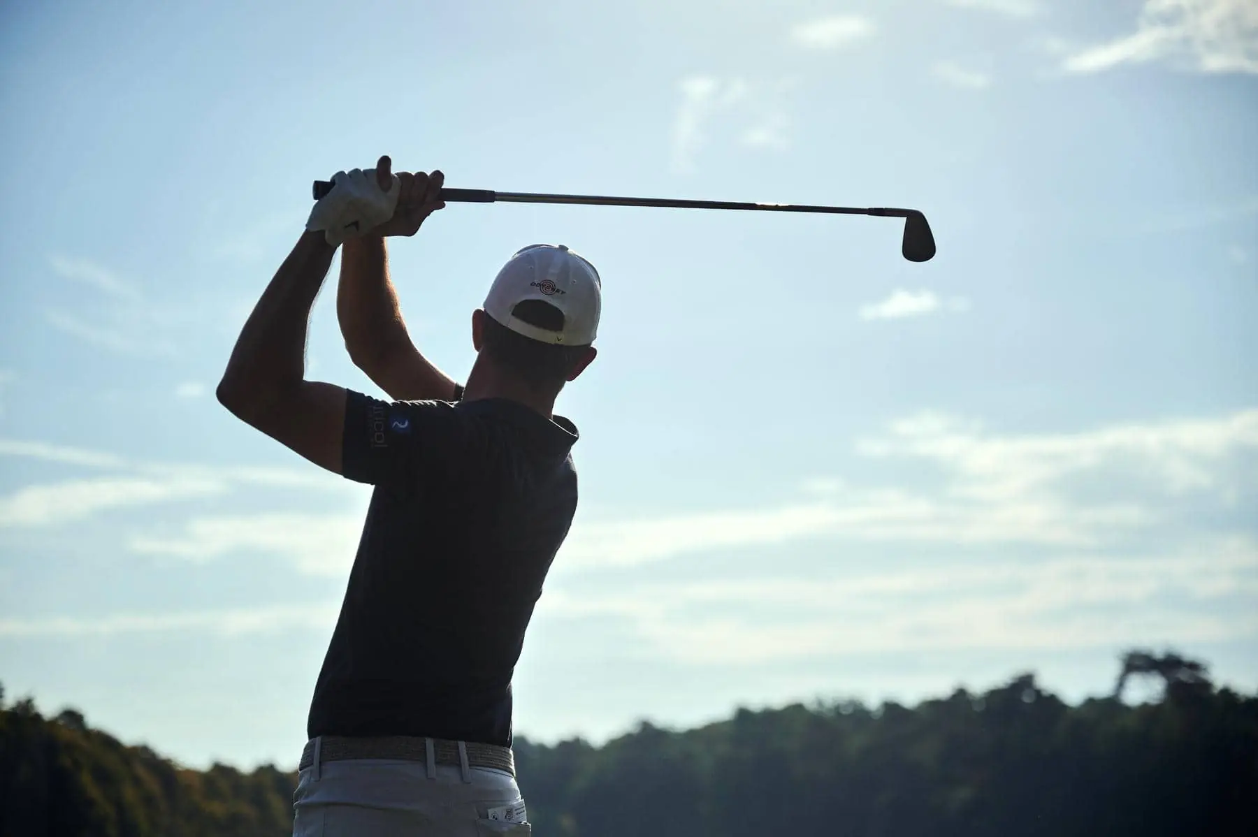 un homme brandissant un club de golf avec une casquette de taureau rouge