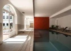 une grande piscine couverte avec un mur rouge