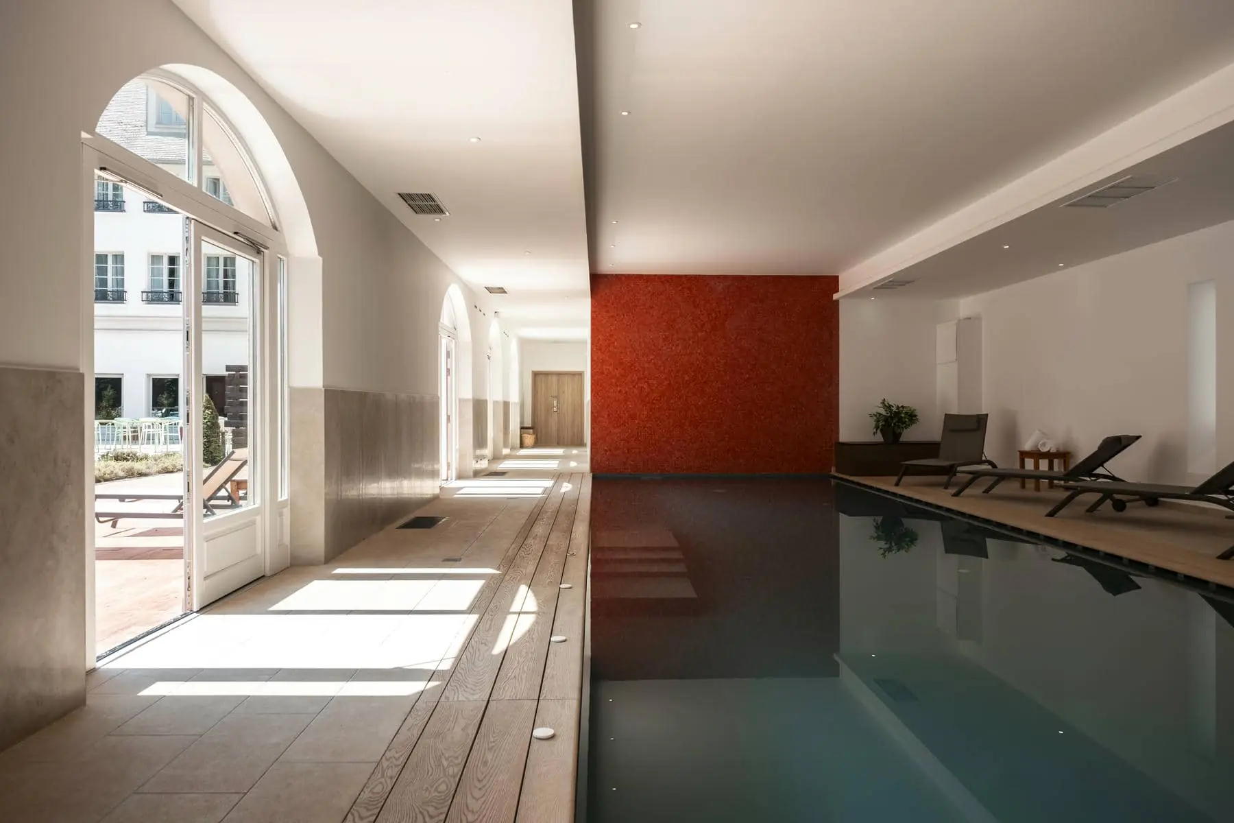 une grande piscine couverte avec un mur rouge