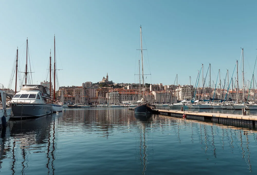 des bateaux sont amarrés dans un port avec une ville en arrière-plan