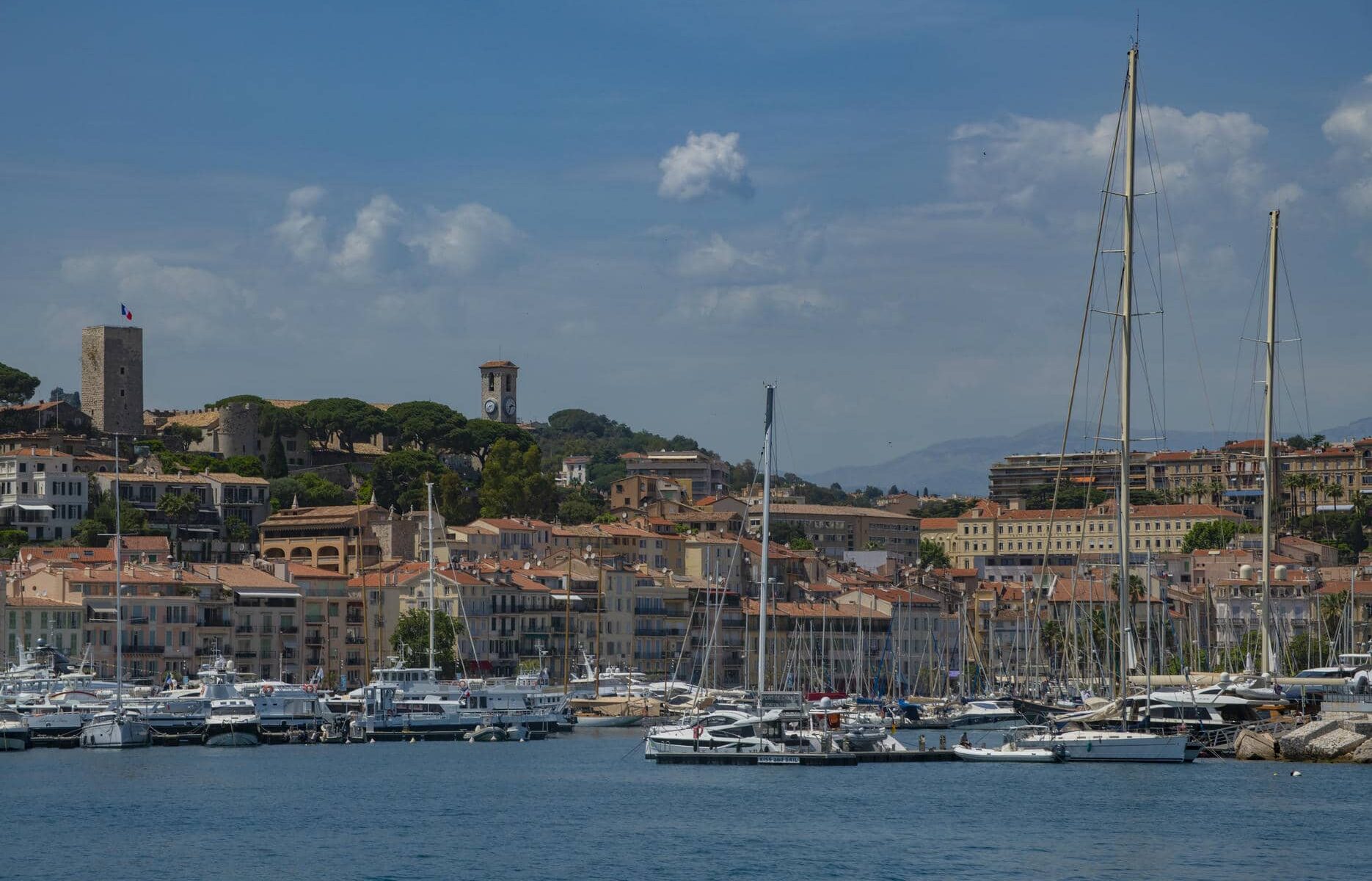 many boats are docked in a harbor with a city in the background