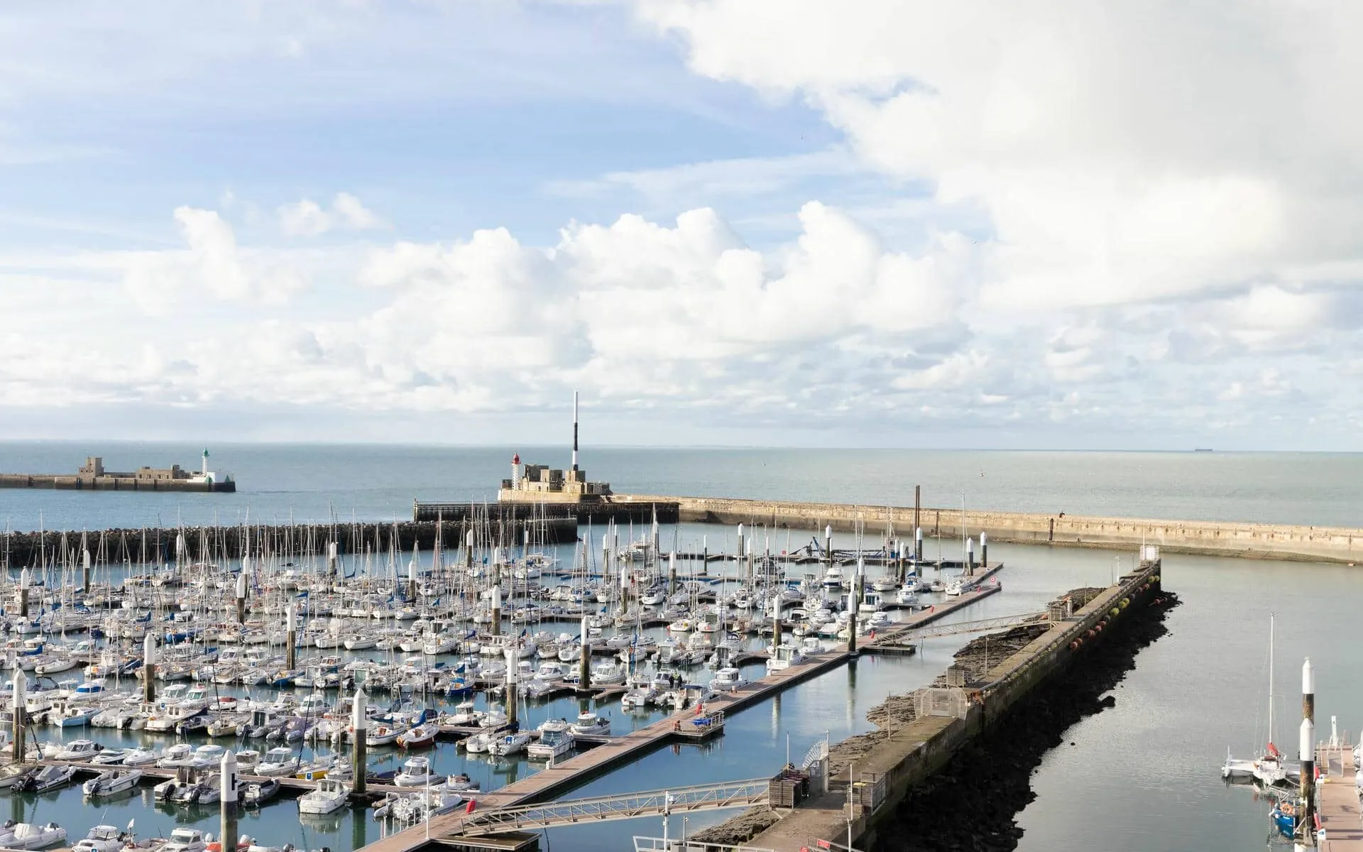 des bateaux sont amarrés dans un port de plaisance avec un château en arrière-plan