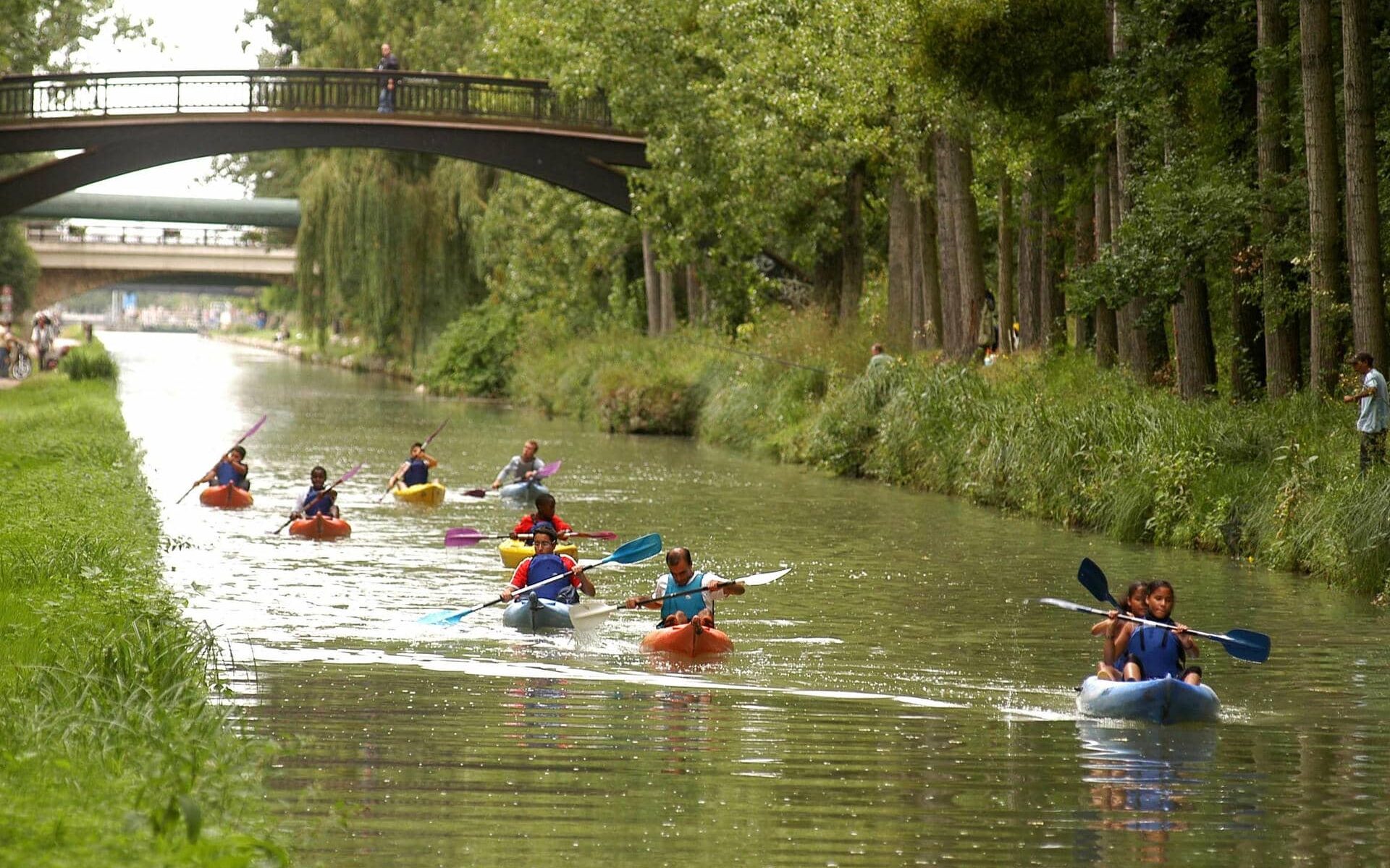 a group of people are paddling kayaks down a river