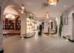 en::the hotel entrance with access to the library, the cinema lounge, the reception desk, the grocery boutique, the bar-restaurant, and the meeting rooms fr::entrée de l'hôtel avec accès à la bibliothèque, au ciné-lounge, à la réception, à la boutique-épicerie, au bar-restaurant et aux salles de réunion