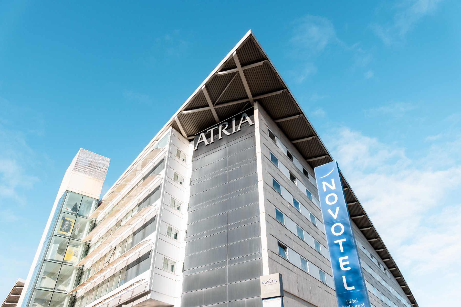 view of the upper part of the Novotel Belfort Centre Atria hotel façade, rising toward the sky