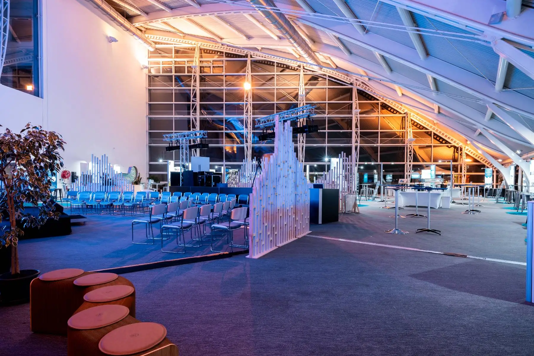close-up within an exhibition room set up as a professional trade show, focusing on the conference and screening area