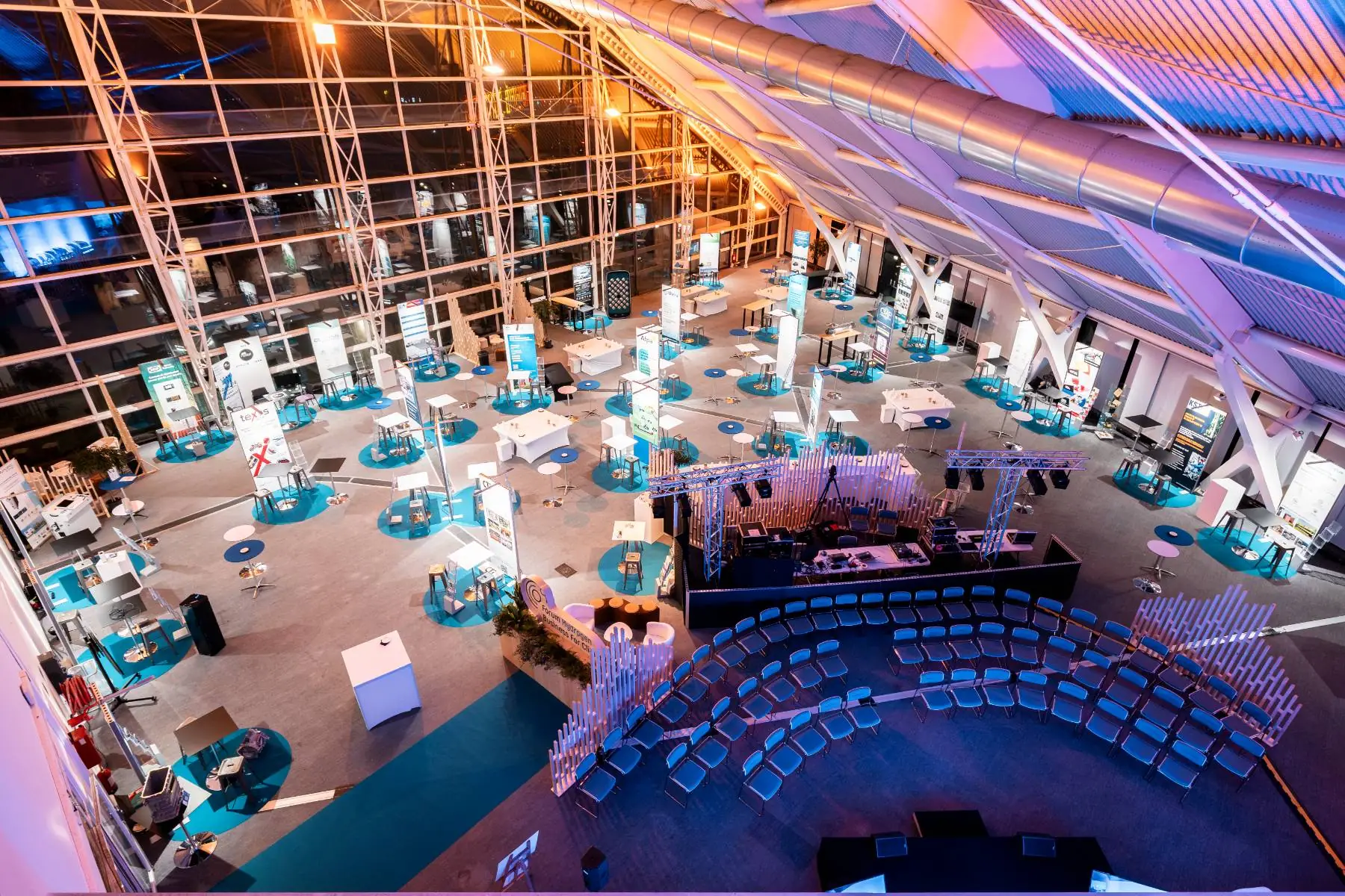 low-angle night view of an exhibition room set up as a professional trade show, with exhibitor stands