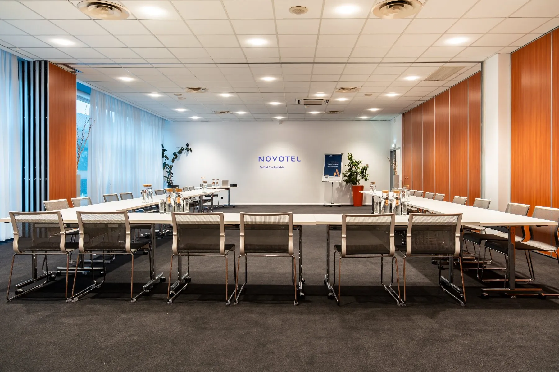 rows of chairs arranged in a U-shape in the Nobel 2 meeting room, air-conditioned, with plants, welcome drinks, view facing the entrance door
