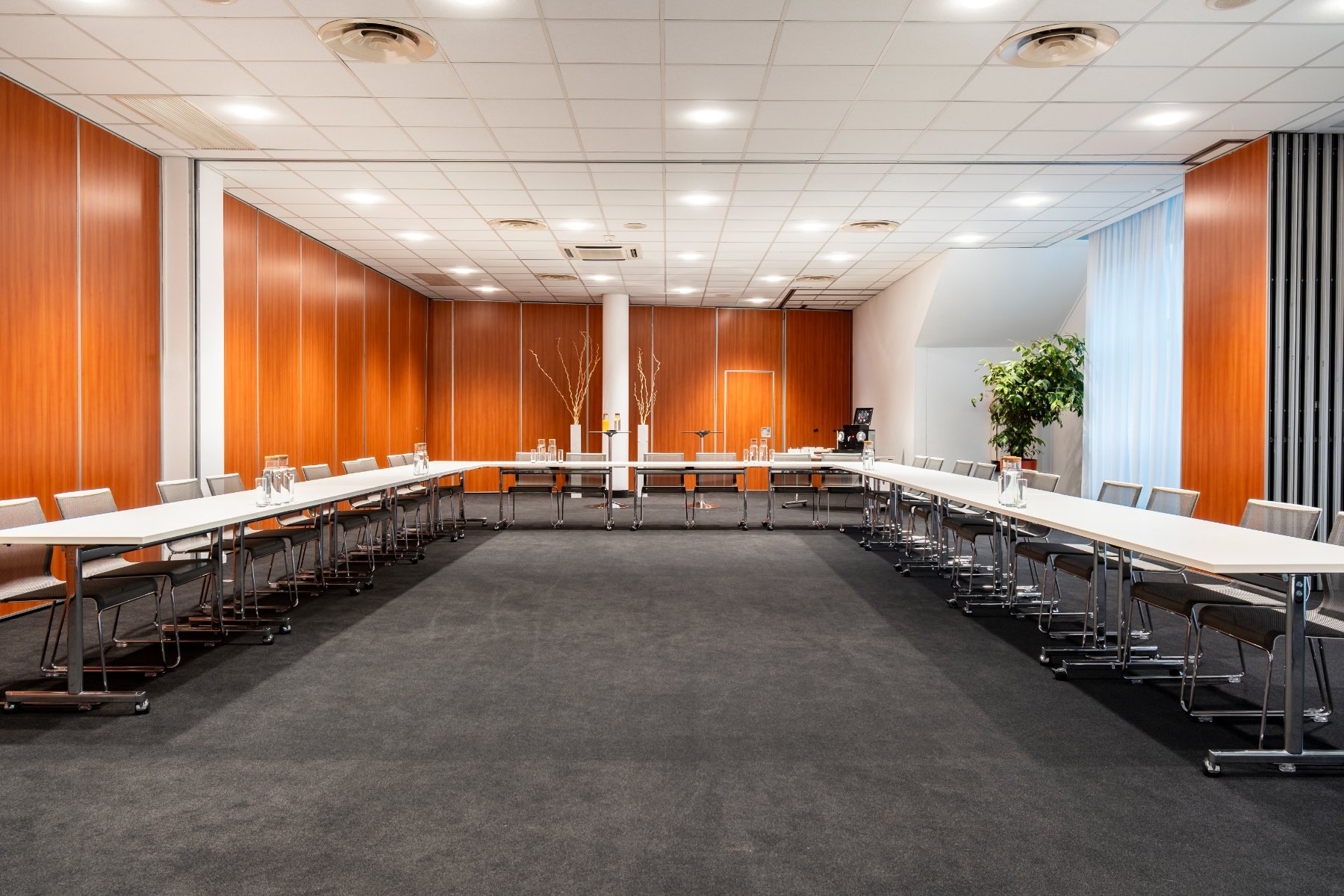 rows of chairs arranged in a U-shape in the Nobel 2 meeting room, air-conditioned, with plants, welcome drinks, view facing the back of the room