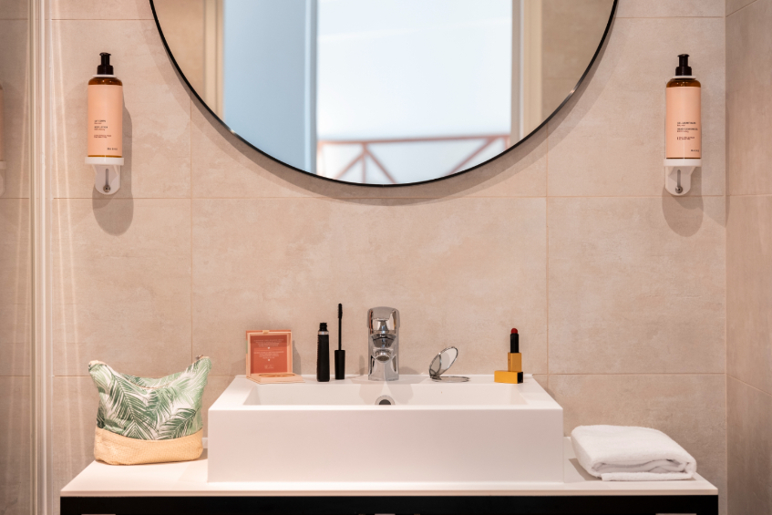 close-up of a bathroom with a rectangular designer sink and a round mirror reflecting half-timbered walls