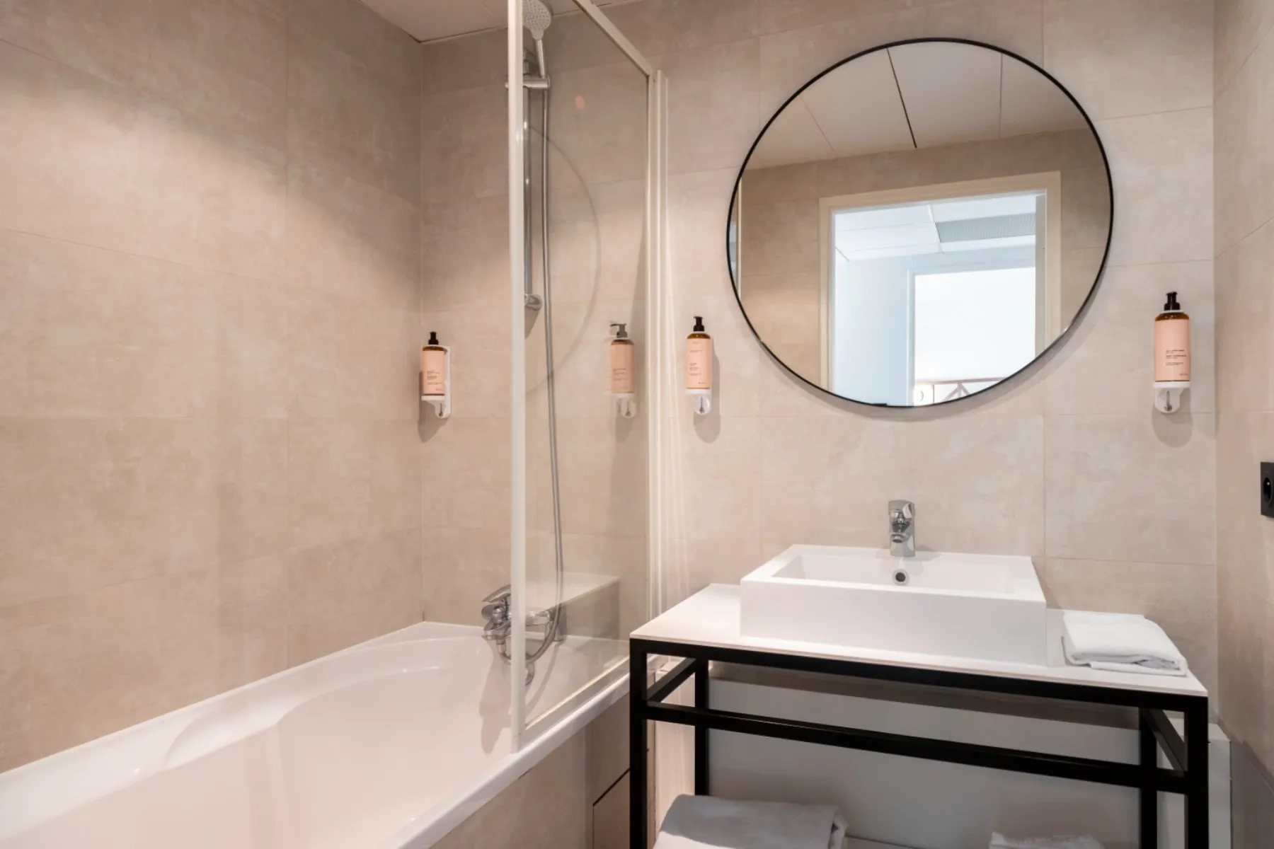 bathroom featuring a sink, a wall-mounted mirror, and a bathtub