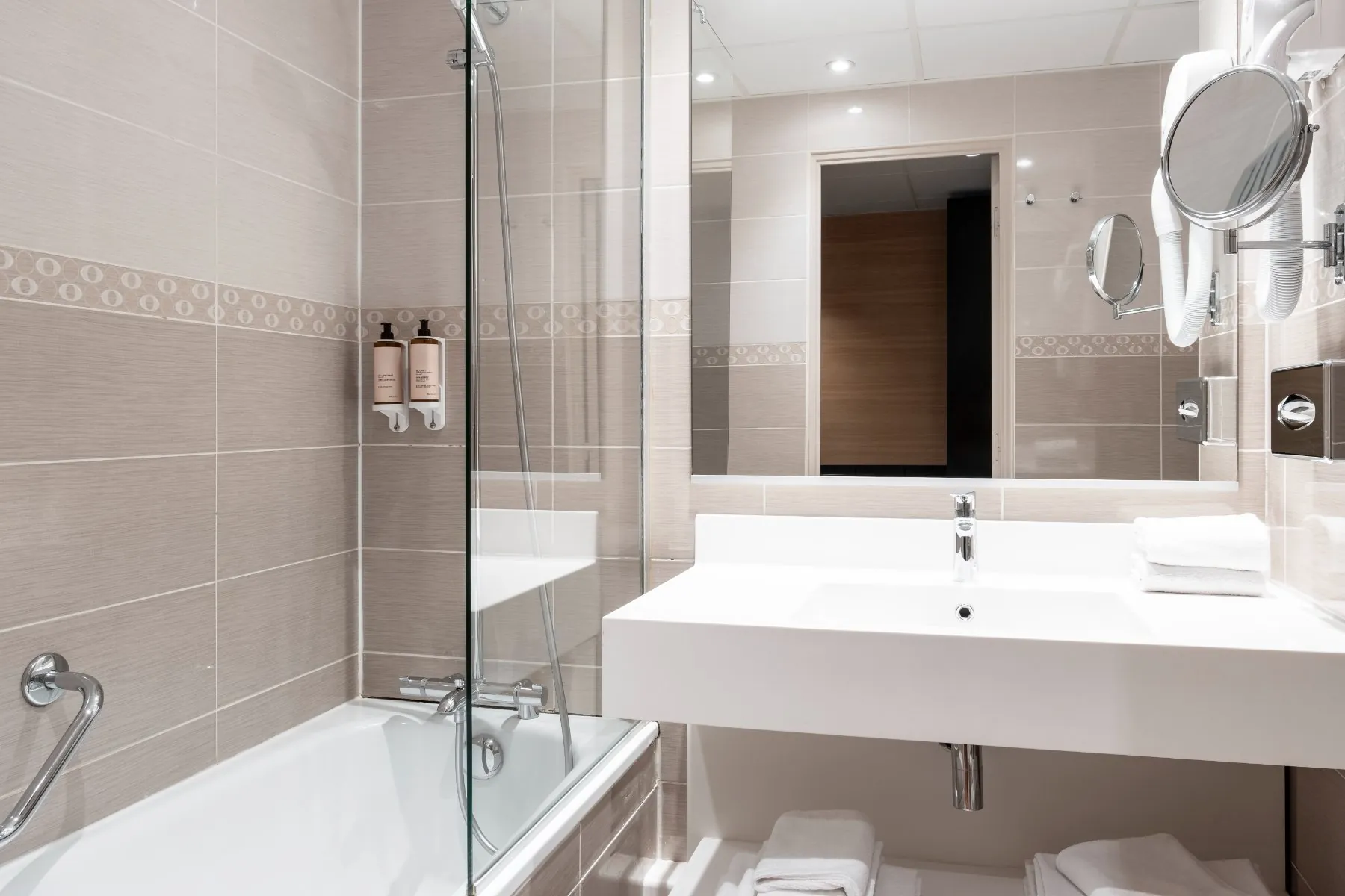 bathroom with a rectangular sink, a wall-mounted mirror, and a bathtub