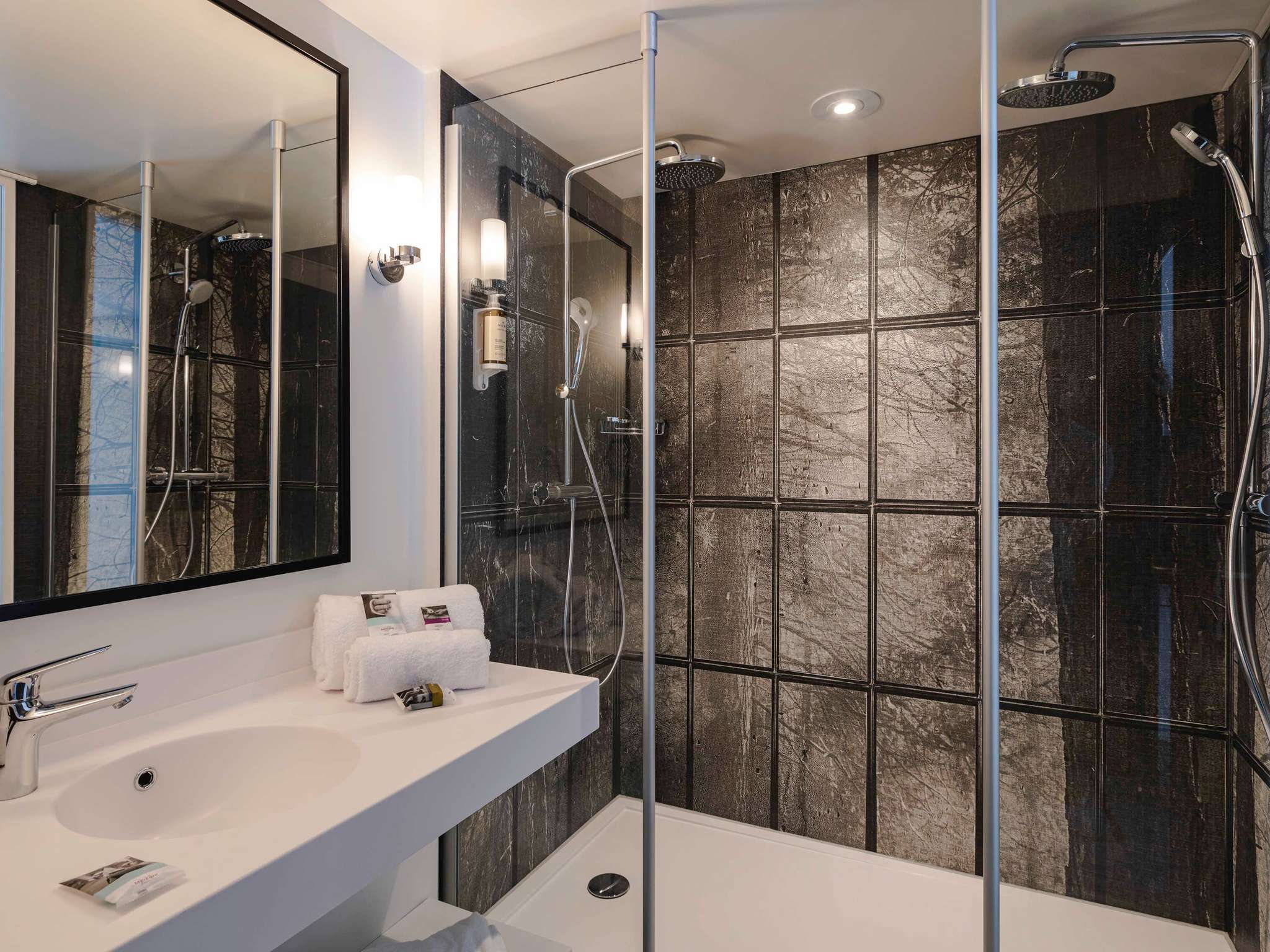 en:: Walk-in shower with bronze wall tiles featuring a pattern of large tree trunks and branching shapes. fr:: Douche à l’italienne avec carrelage mural bronze aux motifs de grands troncs d’arbres ramifiés.