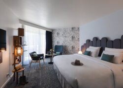 en::Large double bed, carpeted floor with rug, lounge area, wall-mounted TV and terrace. fr::Lit double grande largeur, moquette avec tapis, coin salon, TV murale et terrasse.