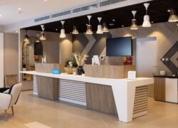 un comptoir d'accueil en bois et revêtement blanc, écran tv, salon lounge