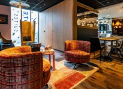 Attenant au lobby et à l’espace bar, un corner jeux avec des assises très colorées de différentes tailles et des stickers Novotel Suites en arrière-plan sur les baies vitrées.