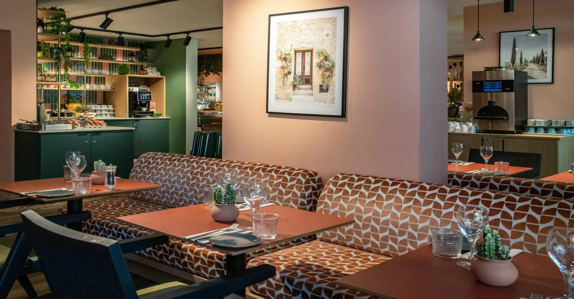Vue d'une salle de restaurant avec chaises, banquettes et tables dressées, espace buffet carrelé, espace café