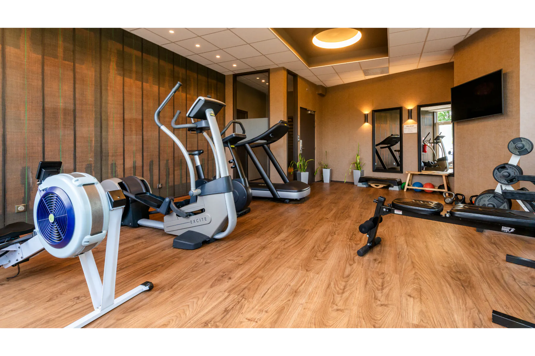 Salle de sport avec plusieurs machines de cardio et de renforcement musculaire