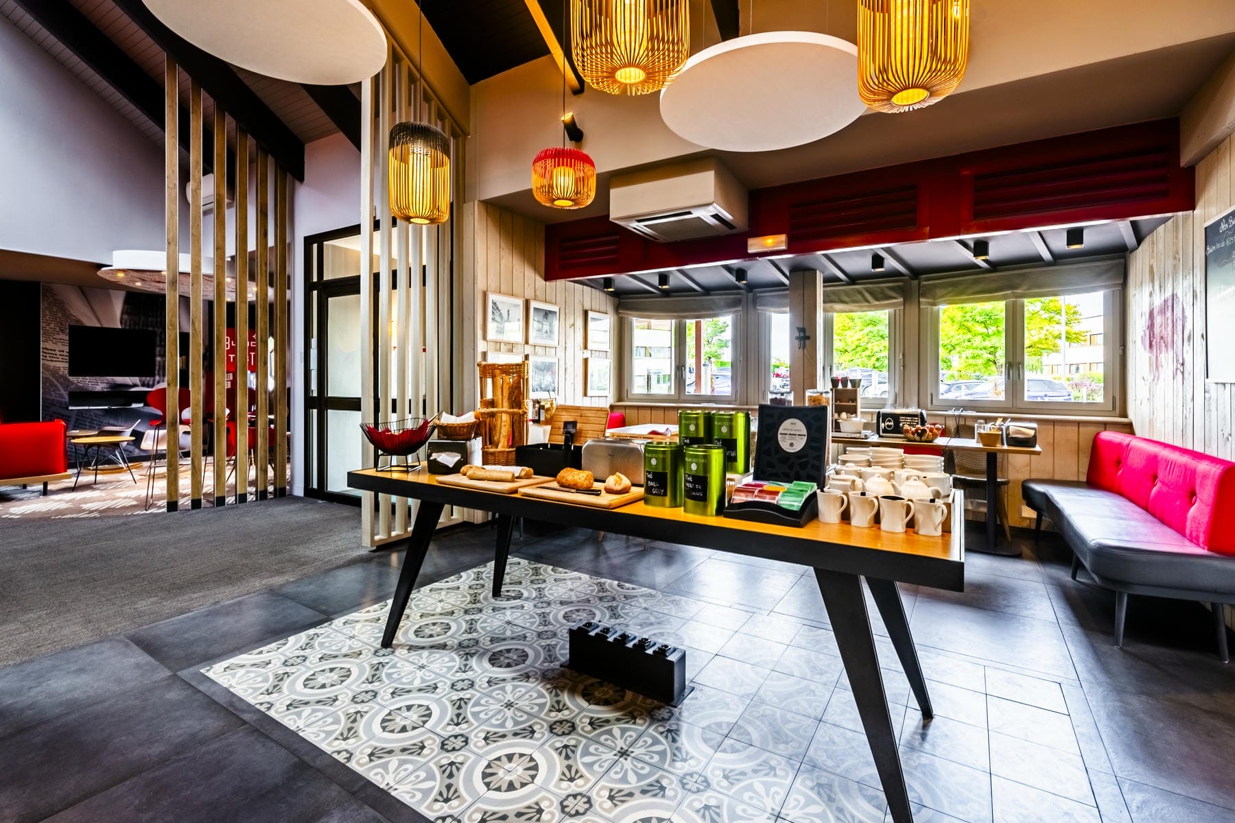 Un espace petit déjeuner avec un buffet garni d'un service à thé et de différents pains.