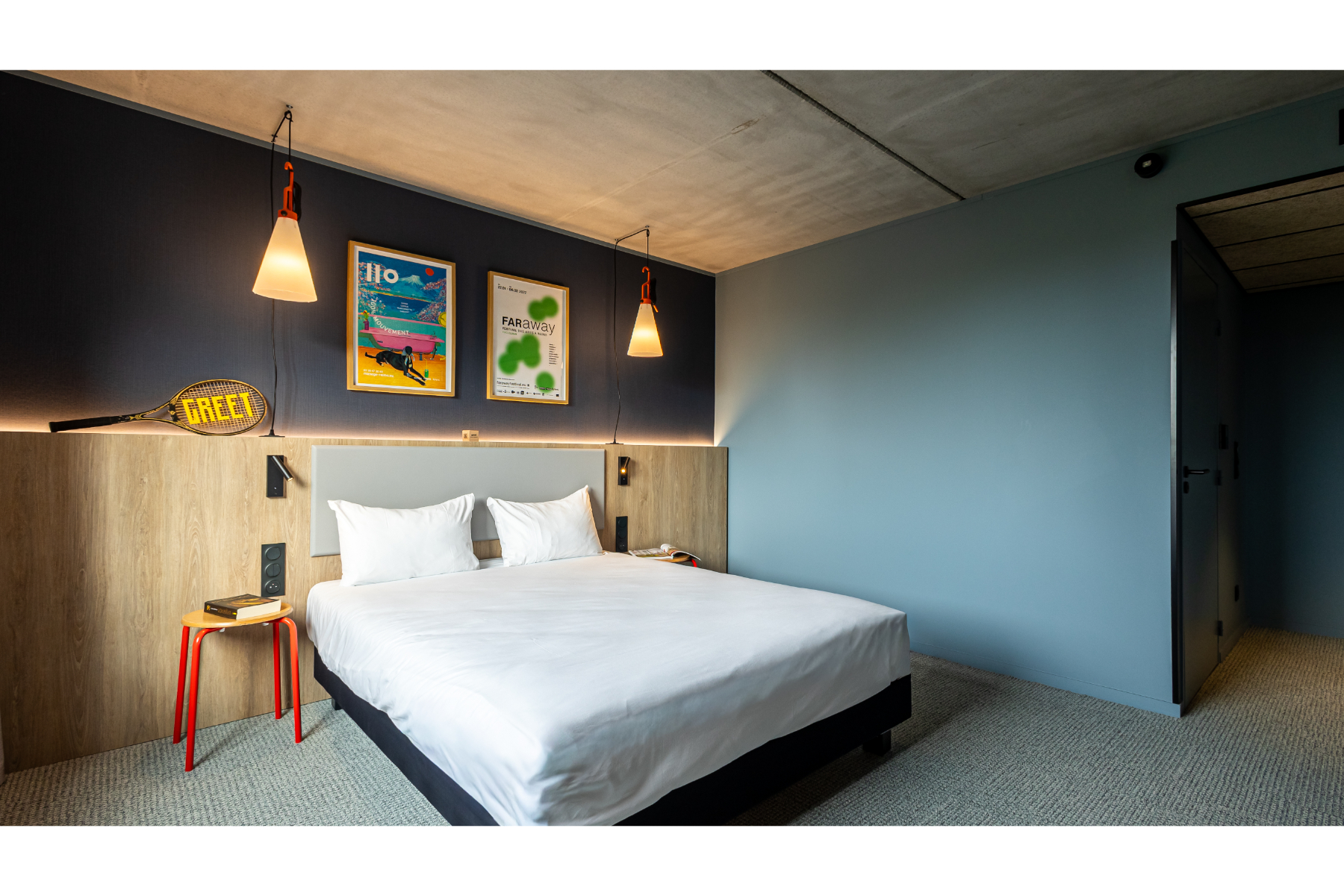 Cette photo d'une chambre à dominante bleue dévoile un large lit double et une décoration sur le thème du sport