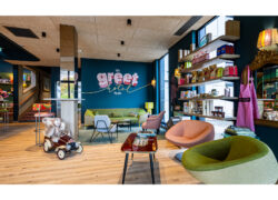 La photo représente le coin lounge de la réception de l'hôtel, avec plusieurs fauteuils au premier plan et un large canapé au fond, ainsi qu'un coin boutique épicerie.