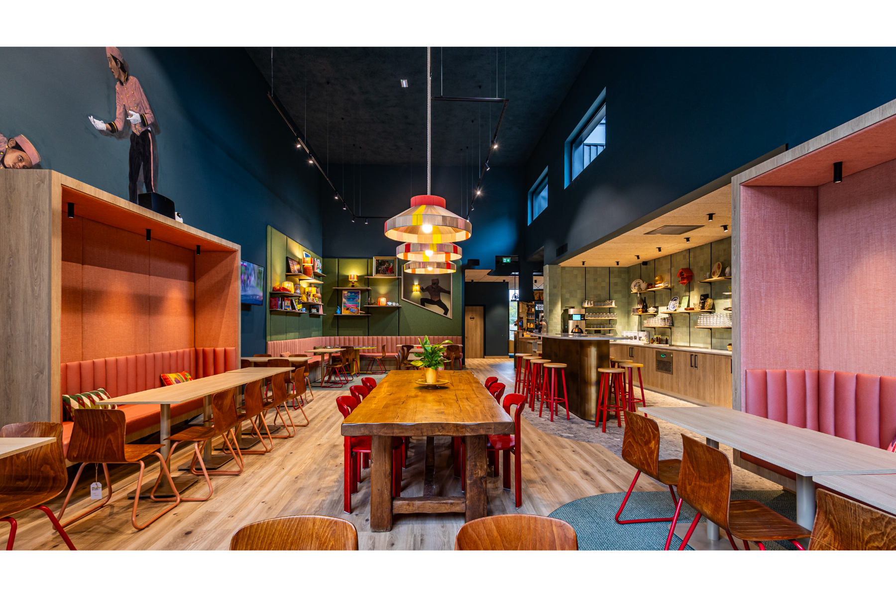 Vue générale de la salle de petit déjeuner avec de longues tablées chaleureuses et conviviales dans un décor pop et coloré