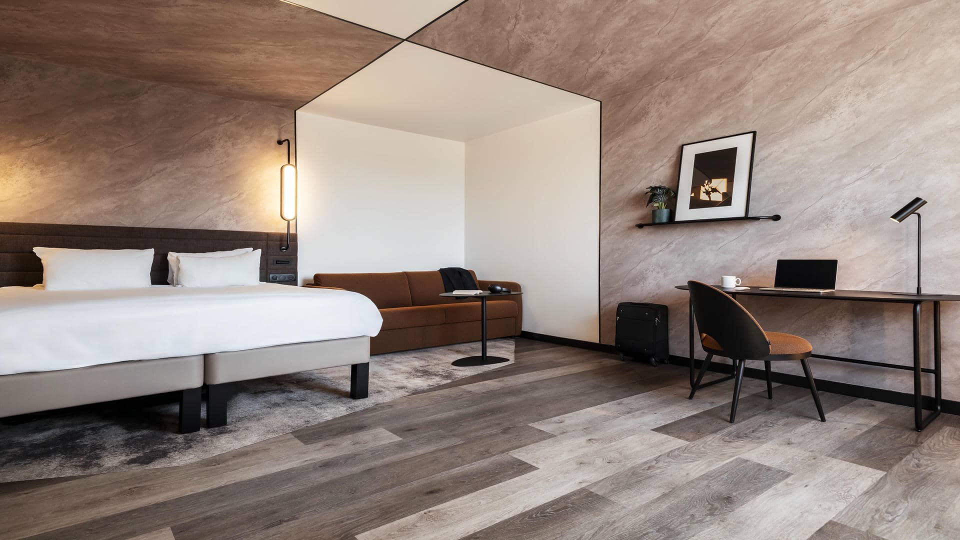 Large double bed with a spacious double sofa bed beside it, facing the desk and the window overlooking the city of Grenoble.