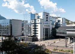 Seminar hotel in Grenoble, shown in daylight under a blue sky, with an exterior view of the building adjoining the CCI and the World Trade Center, just a short walk from the SNCF train station.