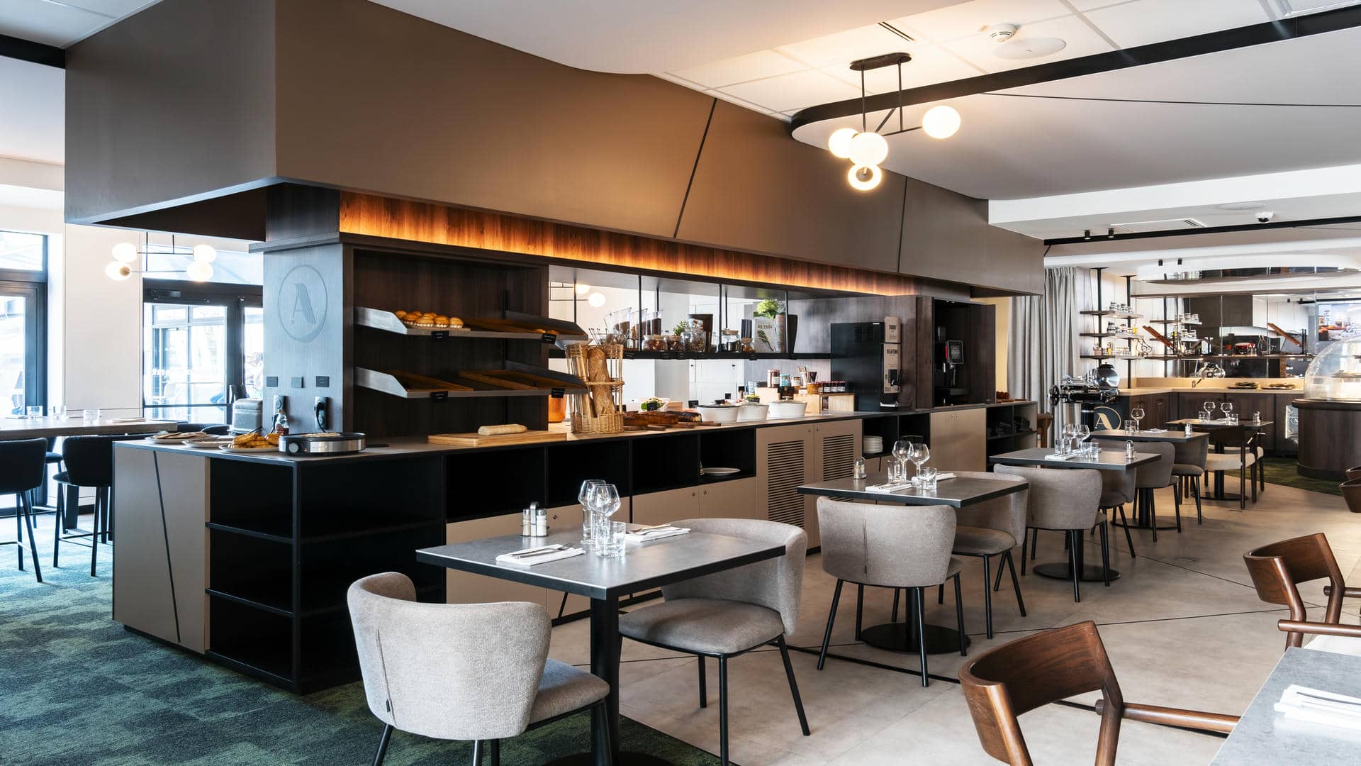 The seminar restaurant features a central buffet area, with tables and chairs arranged on either side. At the back of the room, a giant cheese dome and a cabinet with raclette and fondue equipment highlight the convivial dining experience.