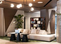 Lobby with bookcase, light beige sofa and coffee area in a seminar venue in Grenoble.