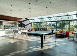 en::Glass-roofed space with a ping-pong table, table football, sofas, children’s play armchairs and a dedicated seminar break counter. fr::Espace sous verrière avec table de ping-pong, baby-foot, canapés, fauteuils de jeux pour enfants et meuble dédié aux pauses séminaires du Novotel Chartres.