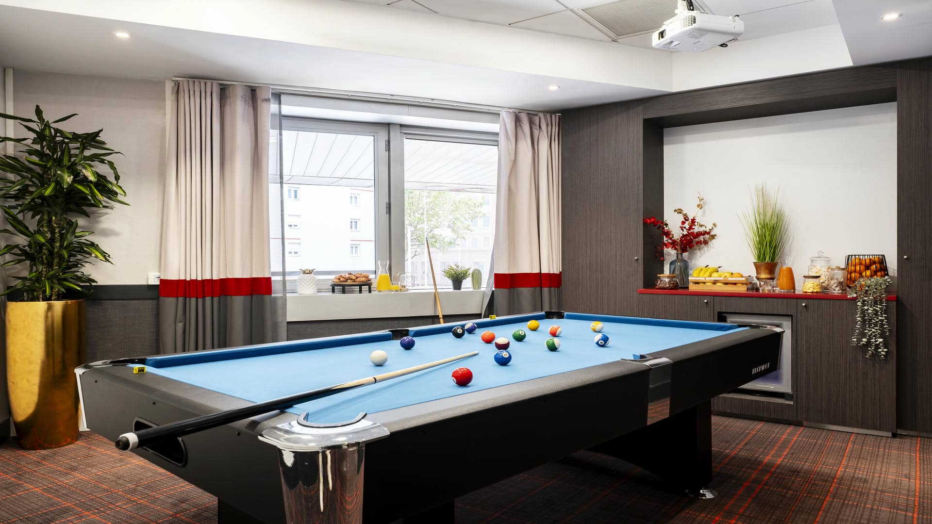 en::Billiard table in a Mercure Paris La Défense meeting room, with fruit, pastries and sweets to enjoy, overlooking the city, ideal for corporate events. fr::Billard dans une salle de réunion du Mercure Paris La Défense, avec fruits, viennoiseries et bonbons, vue sur la ville, pour événements d’entreprise.