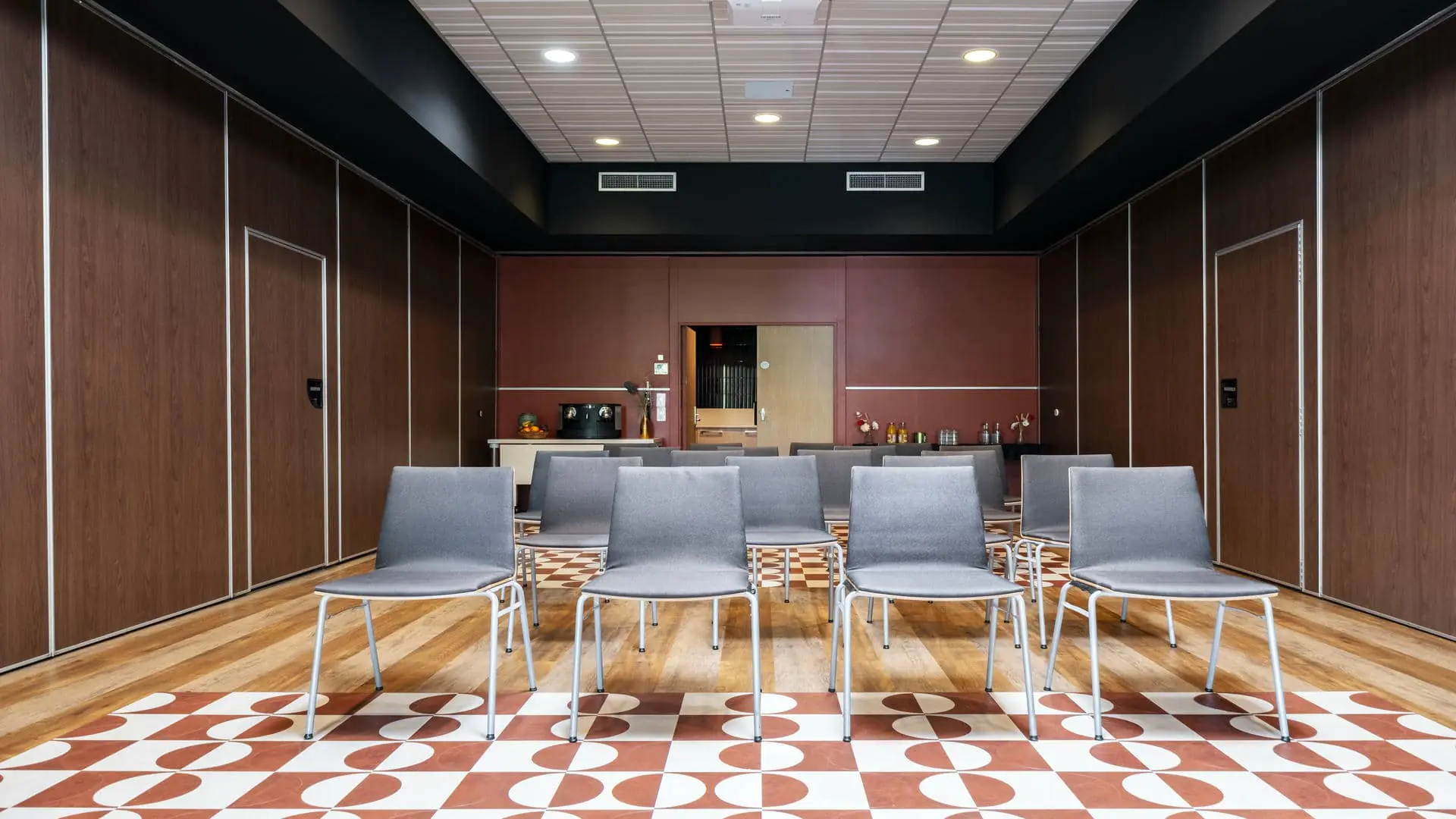 Salle de formation avec chaises disposées face à un écran non visible.