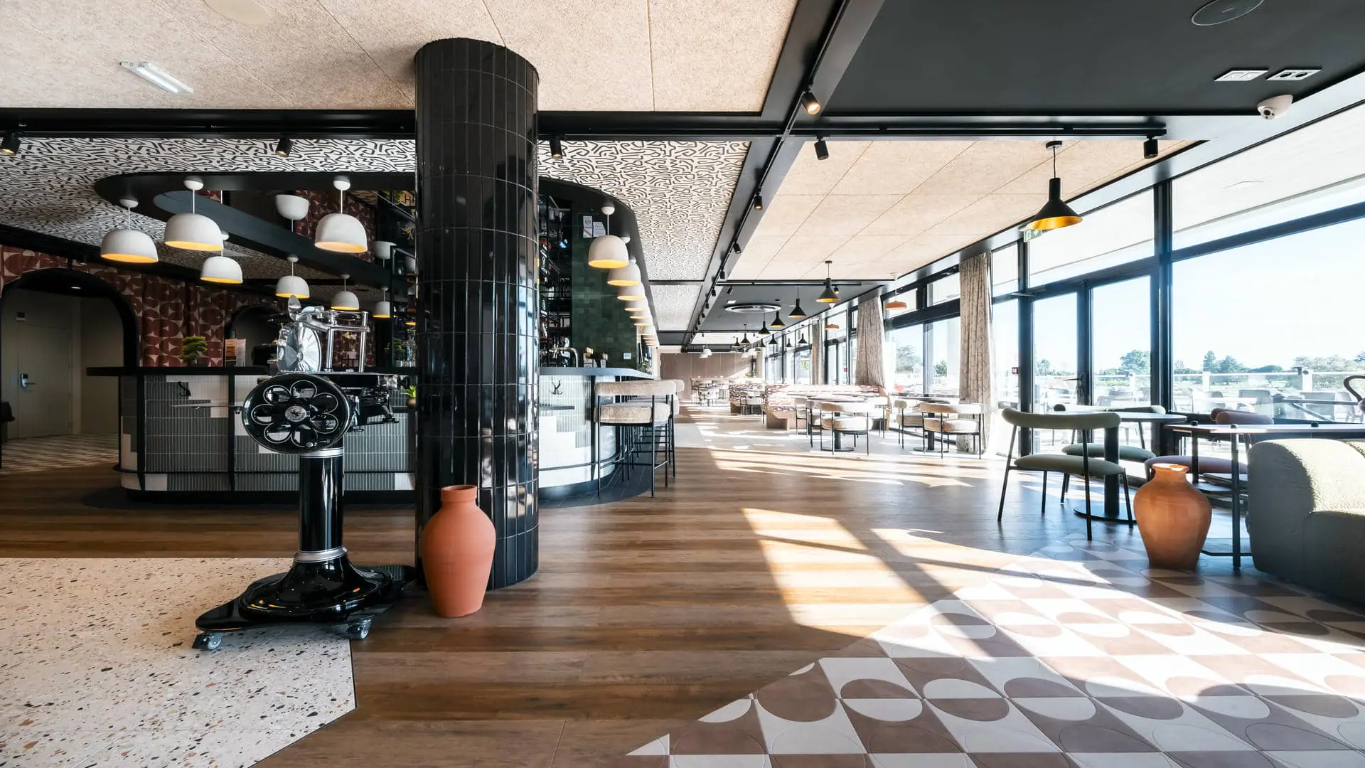 Restaurant séminaire avec bar occupant une grande partie de la salle, vue sur la piscine, la terrasse et le golf, dans un espace très design.