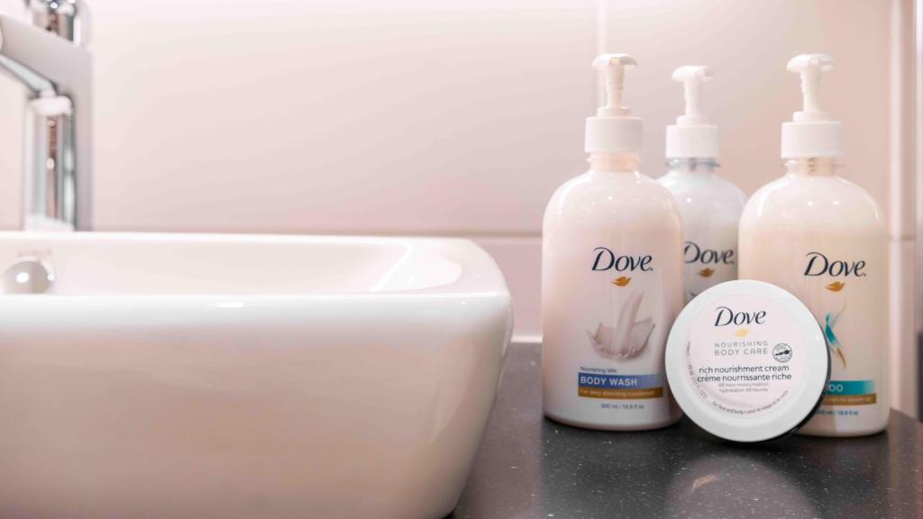 Dove toiletries placed beside a white washbasin.