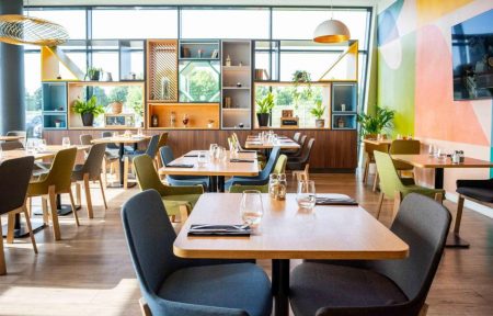 The seminar restaurant features walls, chairs and shelving decorated in shades of pink, green and blue.
