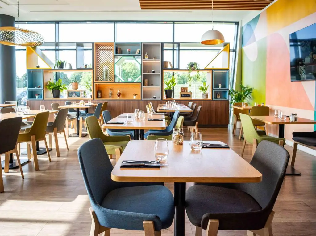 The seminar restaurant features walls, chairs and shelving decorated in shades of pink, green and blue.
