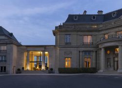 Façade du château de nuit avec éclairage, mettant en valeur les deux étages et la terrasse du restaurant en rez-de-chaussée.