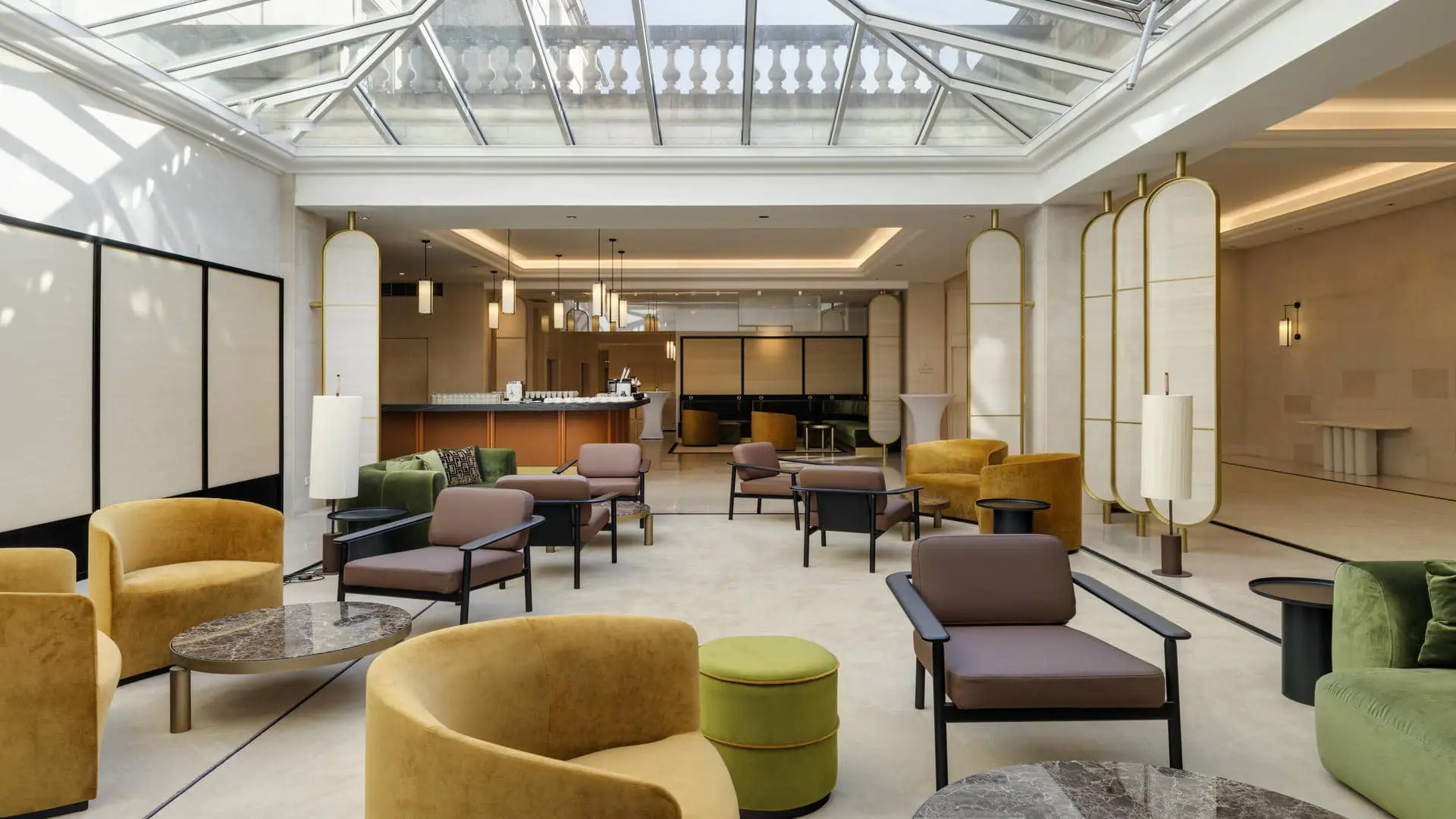 Glass-roofed patio with sofas, armchairs and coffee tables, set up as a seminar break and cocktail area.