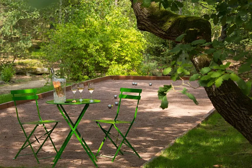 Boules court under the pine trees, with a green metal table and green metal chairs, and rosé served in three wine glasses.