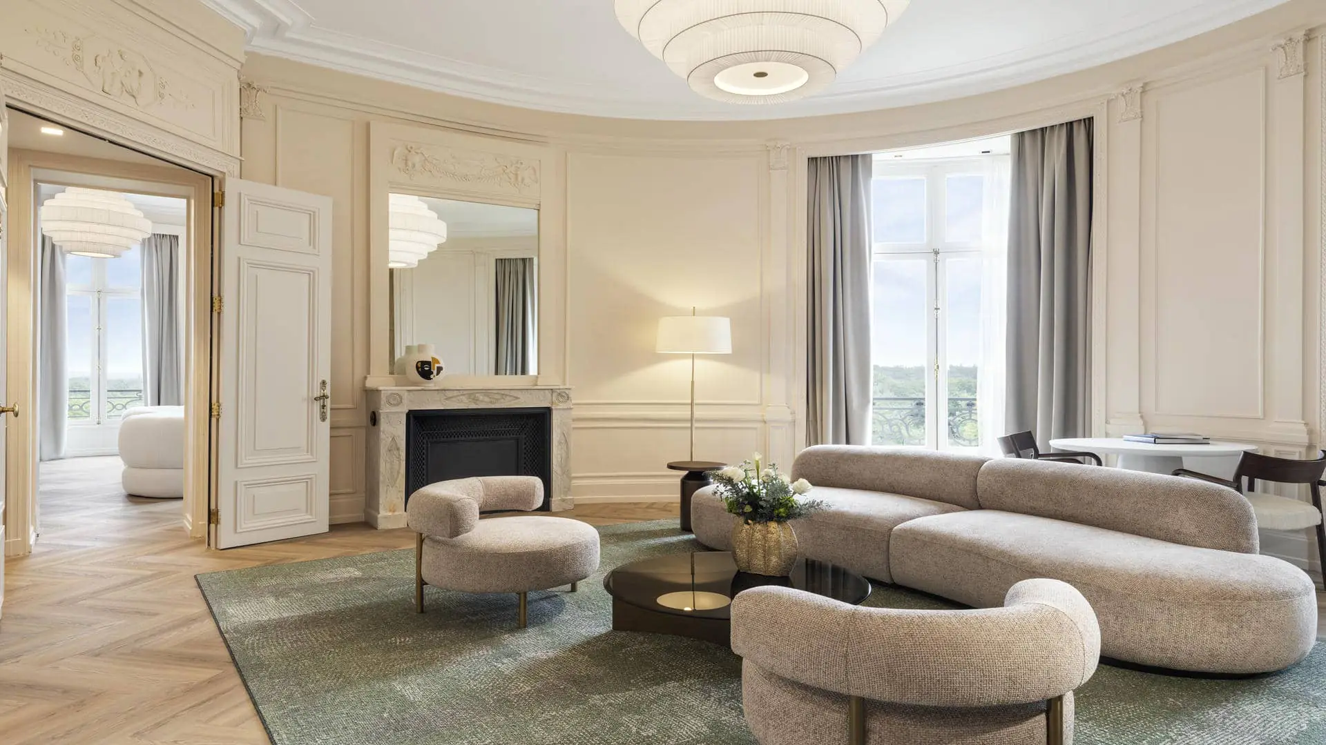 Very large suite with lounge area, table and fireplace, bedroom, and large windows overlooking the forest.