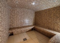 en::a spacious curved sauna in a seminar hotel, fully tiled from floor to ceiling fr::grand sauna d’un hôtel séminaire, entièrement carrelé du sol au plafond, à la forme arrondie