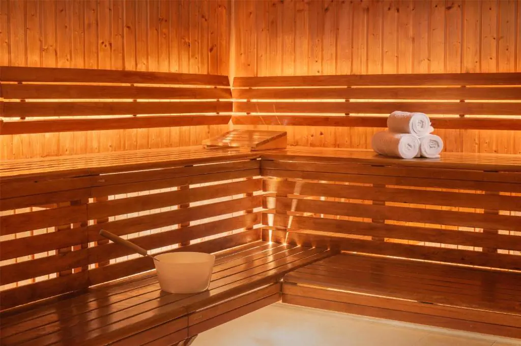 en:: a wooden sauna with rolled white towels and a traditional white bucket fr:: sauna en bois avec serviettes blanches roulées et seau blanc